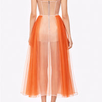 Abito lungo bustier in tulle arancio con base nude in crinolina e drappeggio incrociato